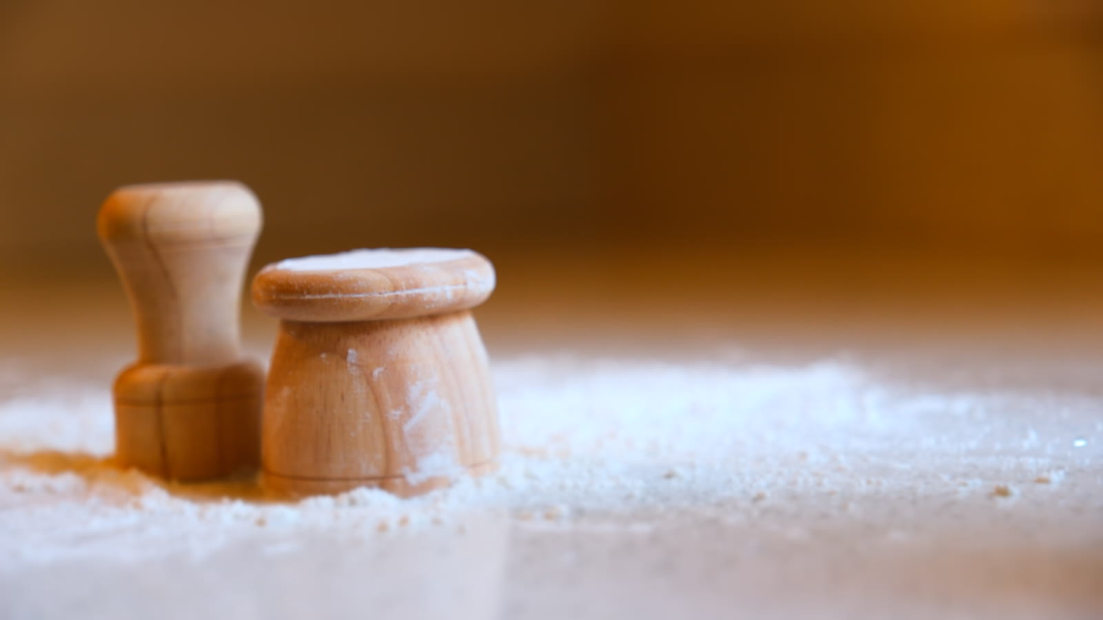 The small and large STAMPLING maple stamps standing in flour on a wooden counter